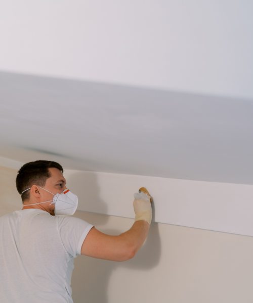 Disinfector washes the walls under the ceiling with a sponge